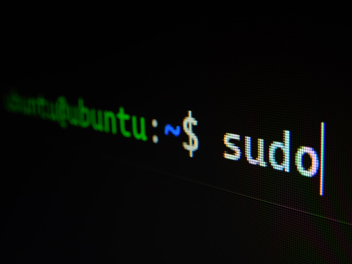 Laptop screen showing a dark terminal with green code on a desk
